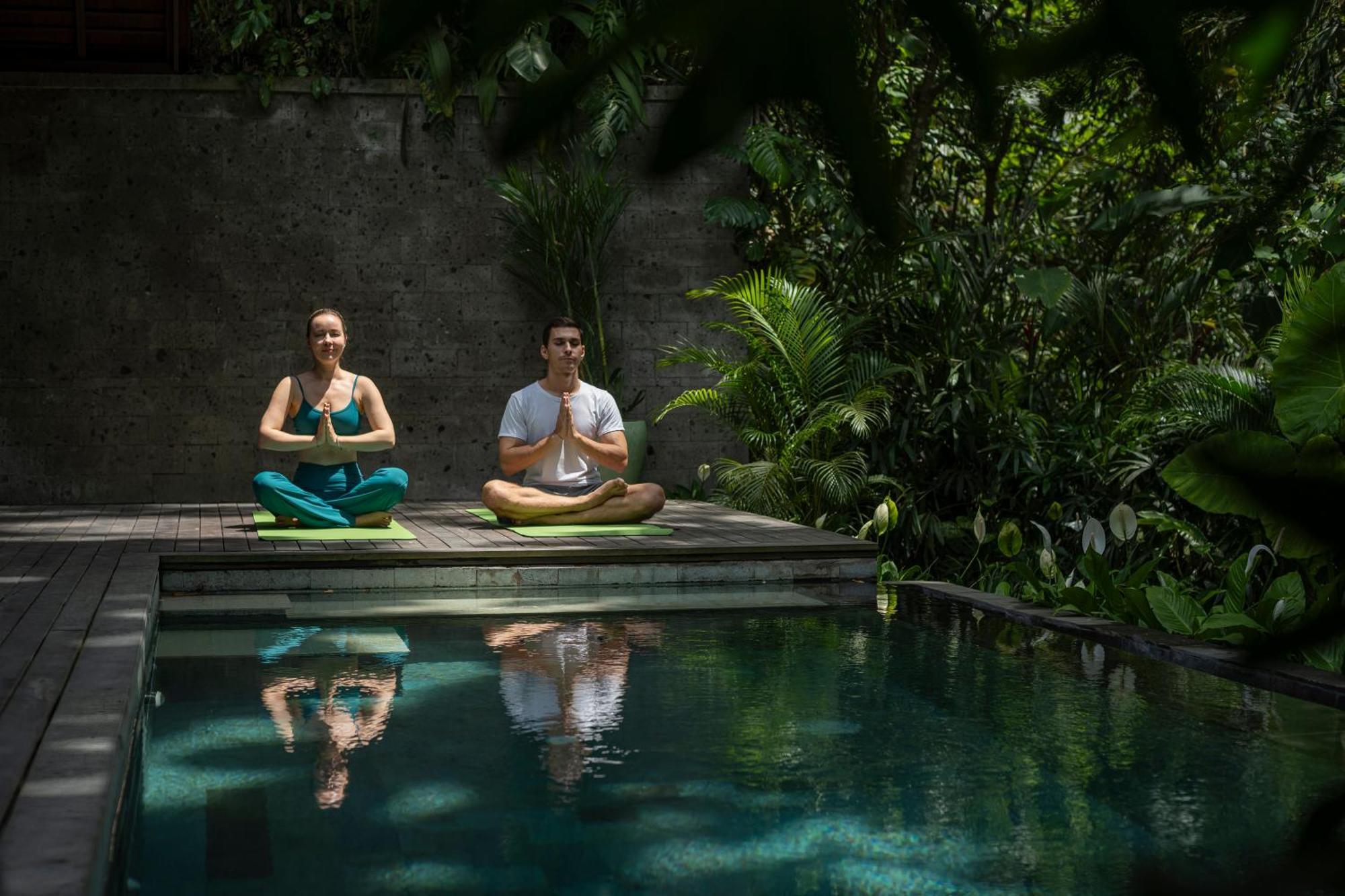 Hotel Adiwana Suweta Ubud Esterno foto A couple practicing yoga at the Bvlgari Spa